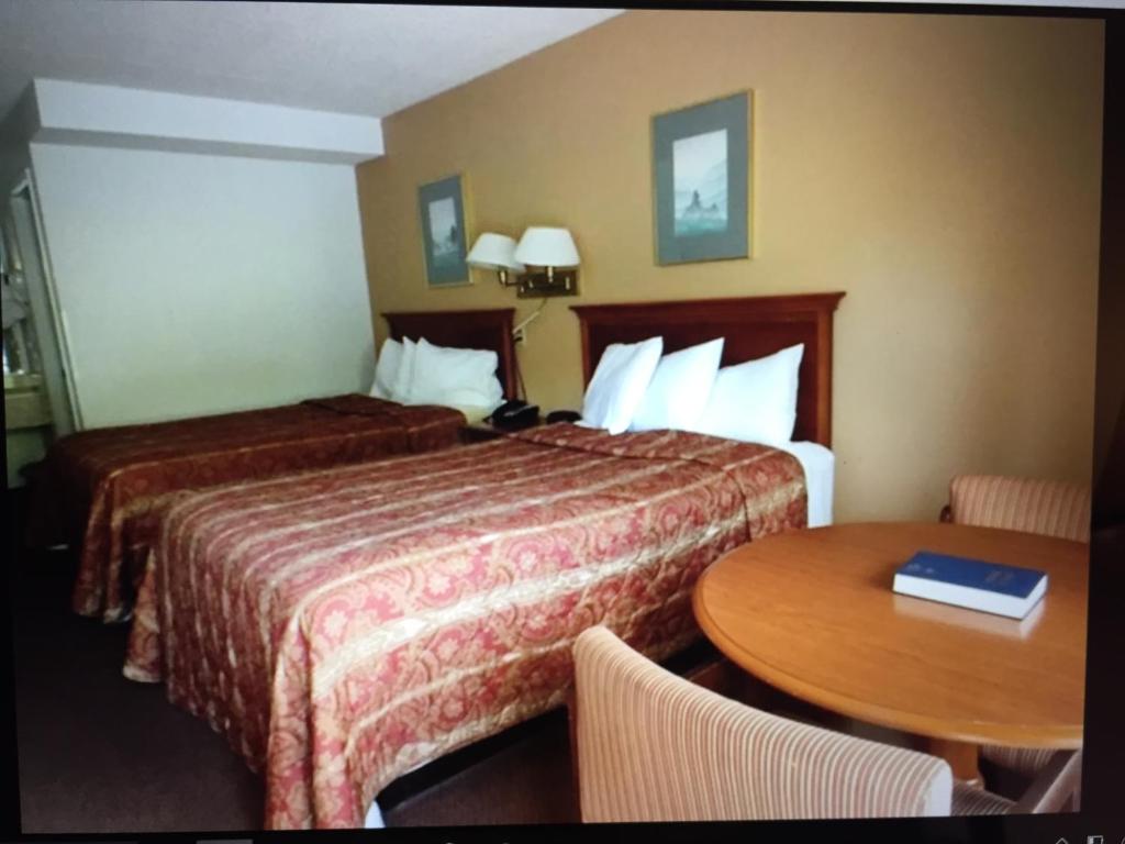 a hotel room with two beds and a table at Motel 6 Fancy Gap VA in Fancy Gap