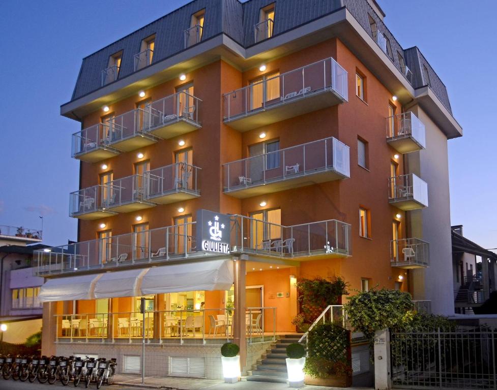 a tall orange building with a sign in front of it at Hotel Giulietta in Senigallia