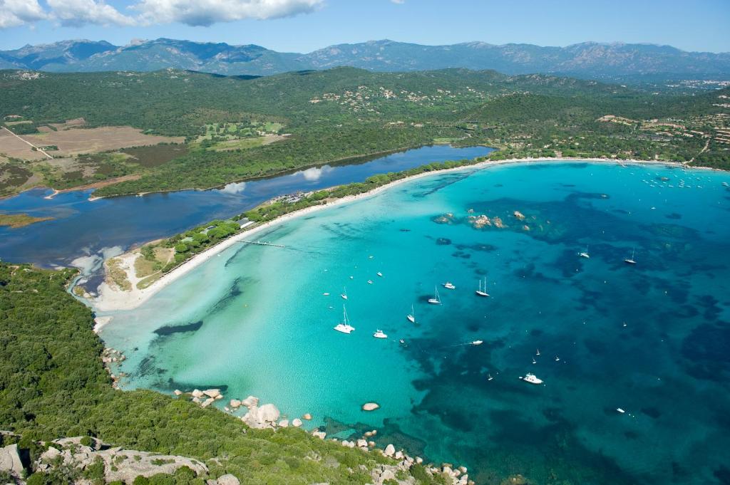 an aerial view of a beach with boats in the water at Hôtel & Lodges Moby Dick in Porto-Vecchio