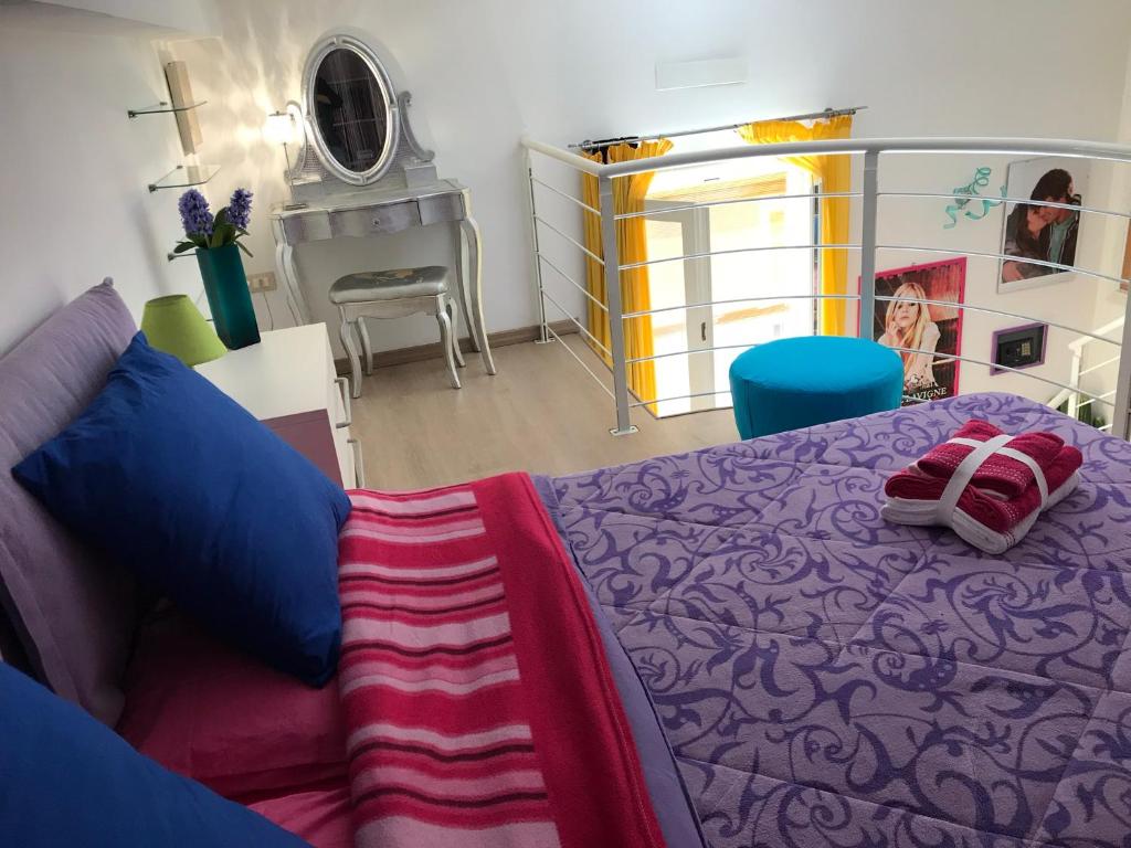 - une chambre avec un lit violet et un canapé dans l'établissement Loft delizioso, à Cagliari