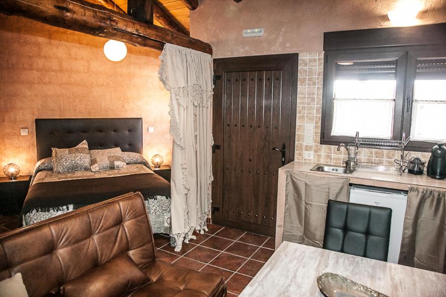 - une chambre avec un lit et un lavabo dans l'établissement Apartamentos Rurales El Casarejo, à Cantalojas