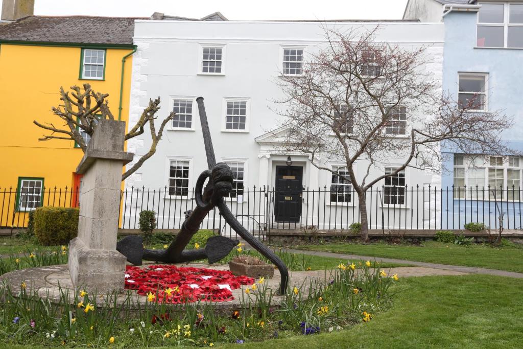 Monmouth House Apartments, Lyme Regis Old Town, dog friendly, parking في ليم ريجيس: تمثال في حديقة امام مبنى