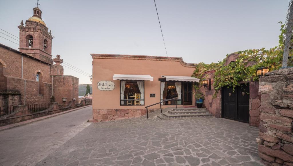 a building on a street next to a church at Hotel Misi&oacute;n Cerocahui a Balderrama Collection Hotel in Cerocahu&iacute;