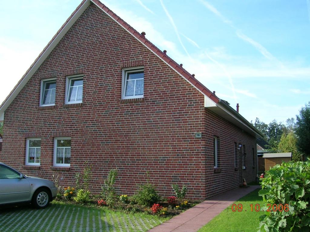 a red brick house with a car parked in front at Ferienhaus Seestern in Hamswehrum