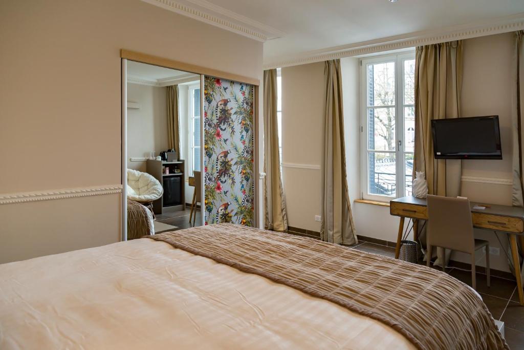 Habitación de hotel con cama, escritorio y espejo. en Hotel Jean Moët, en Épernay