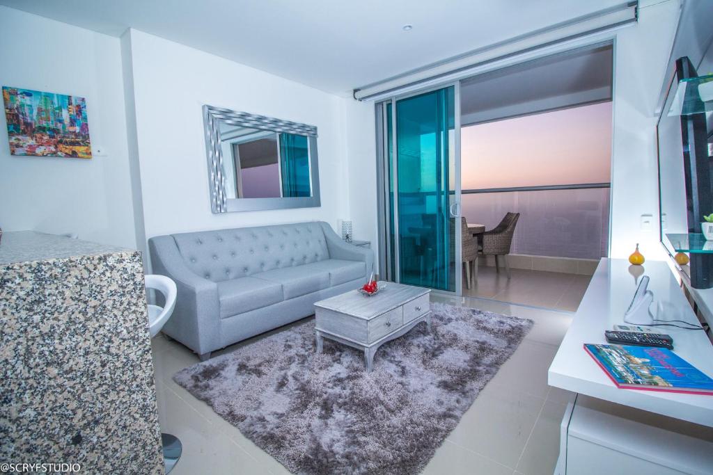 ein Wohnzimmer mit einem Sofa und einem Tisch in der Unterkunft Precioso apto de 1 habitación con vista extraordinaria en Bocagrande in Cartagena de Indias