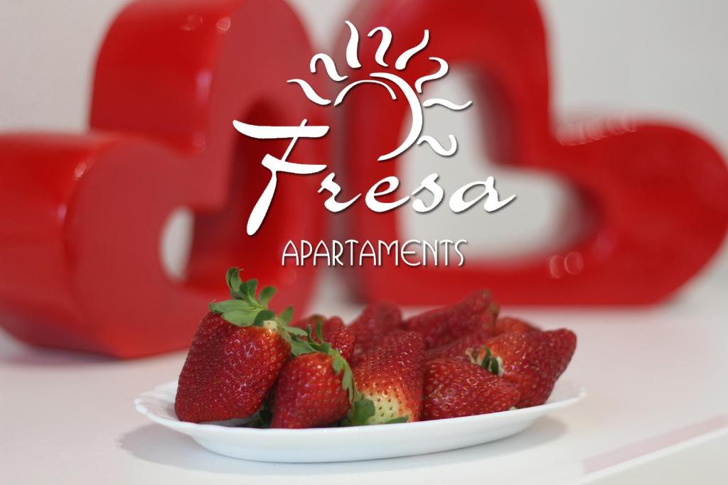 a plate of strawberries in front of a red heart at Fresa Apartaments in La Mata