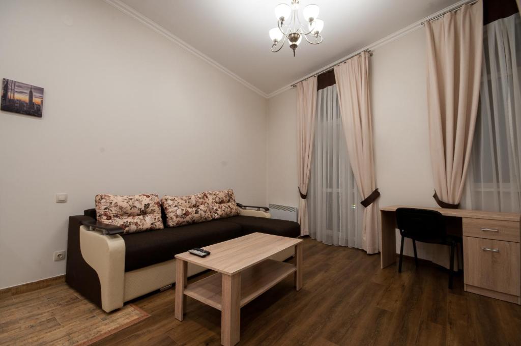 uma sala de estar com um sofá e uma mesa em Wonderful flat on city center (Mukachivska 4/11) em Uzhhorod