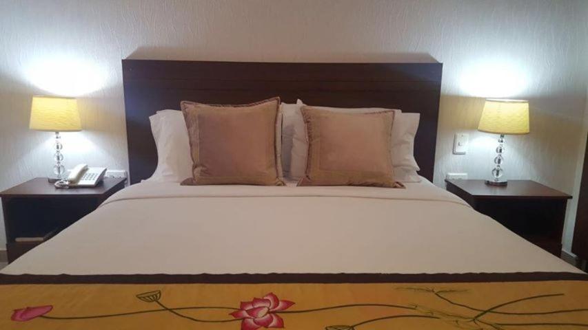 a bedroom with a large bed with two lamps at Casa Murillo Hotel in San Juan del Cesar