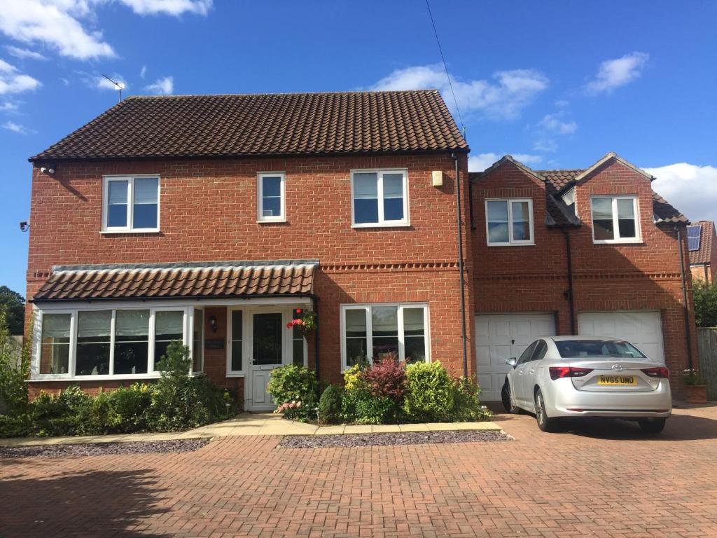 a brick house with a car parked in front of it at Highbury House, Warm and Welcoming. in Darlington