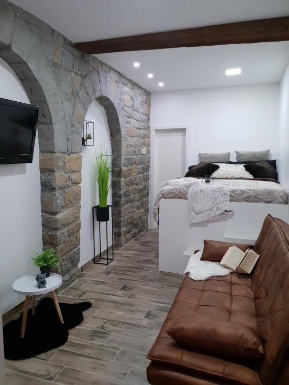 ein Wohnzimmer mit einem Sofa und einem Bett in der Unterkunft Studio Koper in Koper