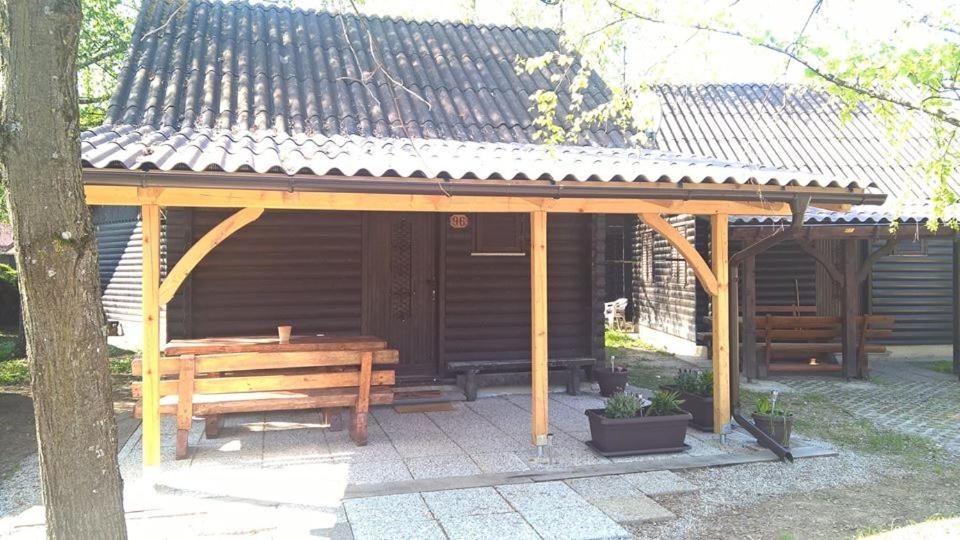 a wooden pavilion with a picnic table and a bench at KRESNIČKA in Čatež ob Savi