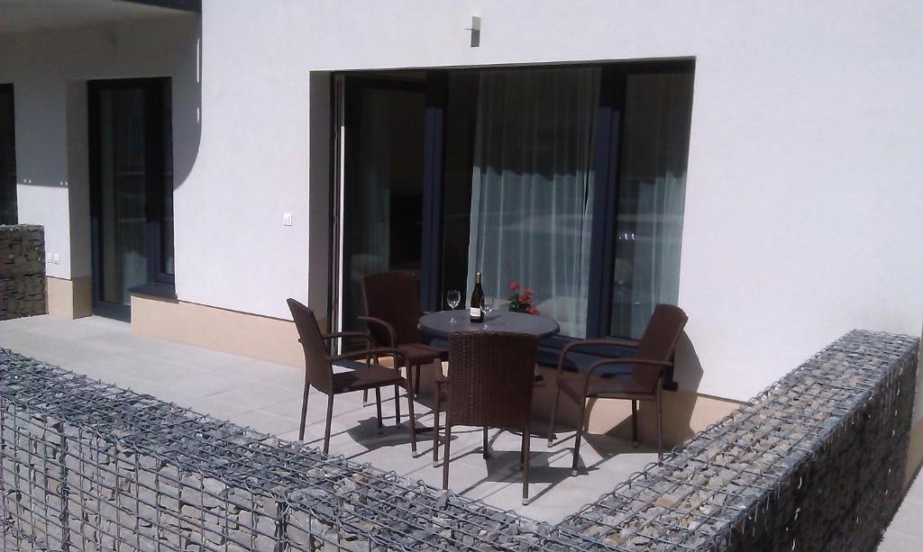 a patio with a table and chairs on a balcony at Sunny, fully furnished Studio type with terrace in Pilsen