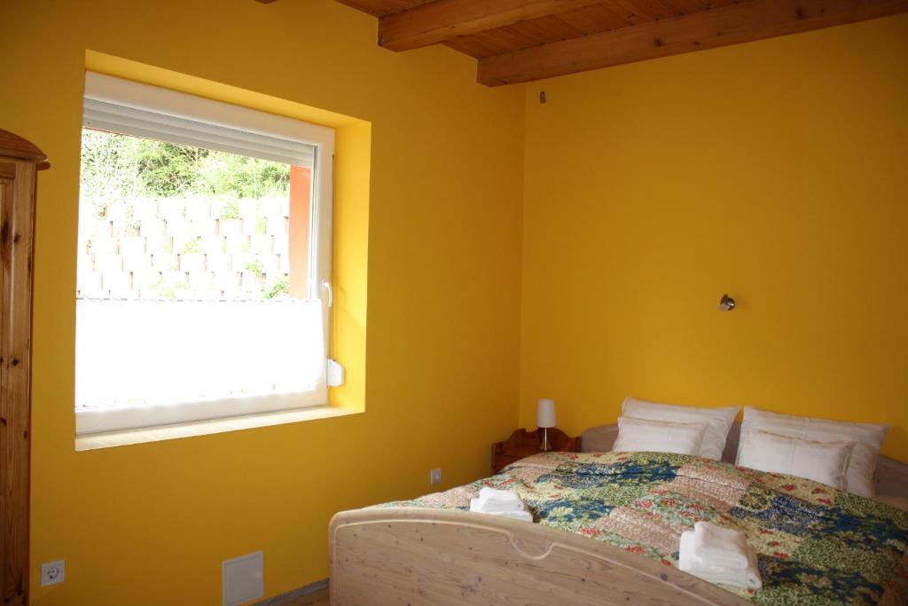 a bedroom with a bed and a window at Kedvenc Vendégház in Miskolctapolca