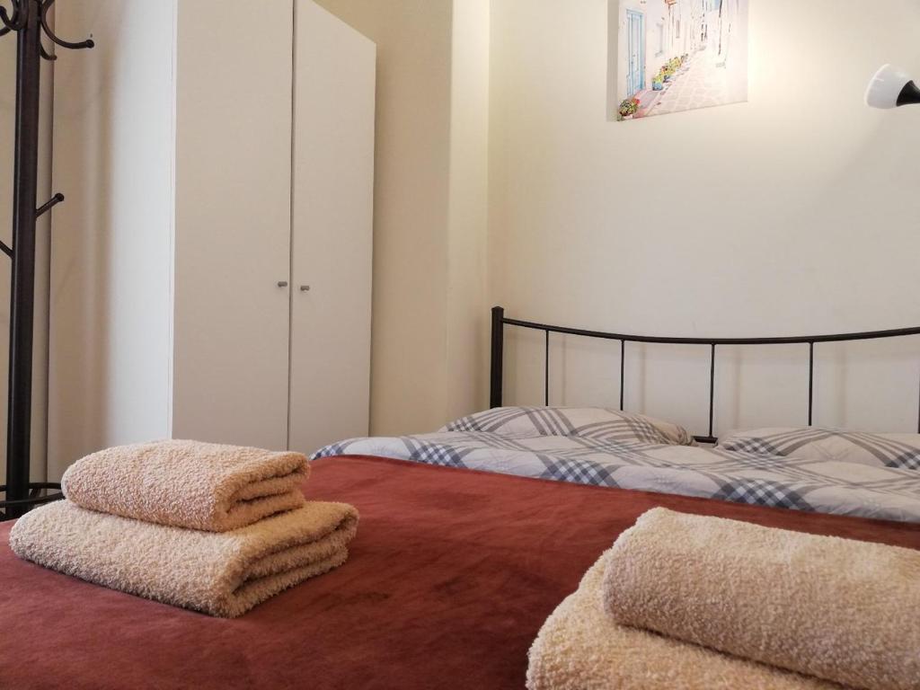 1 Schlafzimmer mit 2 Betten und Handtüchern auf dem Boden in der Unterkunft Sfiggos 54 Guest House in Athen