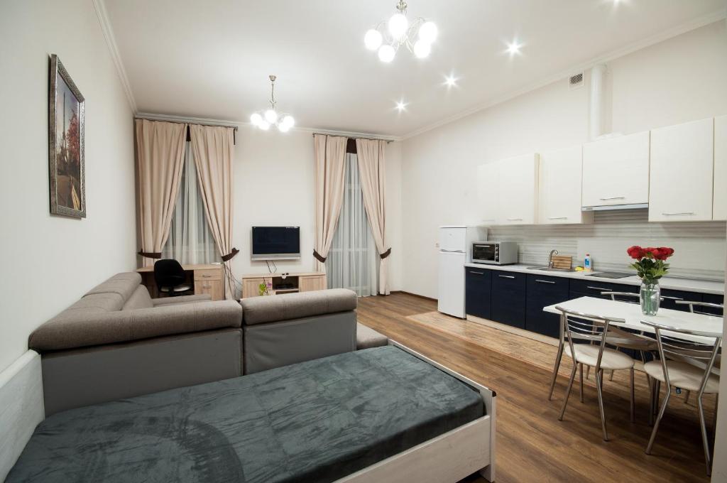 ein Wohnzimmer und eine Küche mit einem Sofa und einem Tisch in der Unterkunft Wonderful flat on city center (Mukachivska 4/14) in Uschhorod