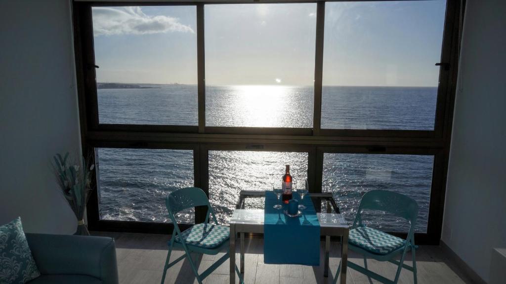 una mesa y sillas con vistas al océano en THE BLUE VIEW MASPALOMAS, en San Agustín