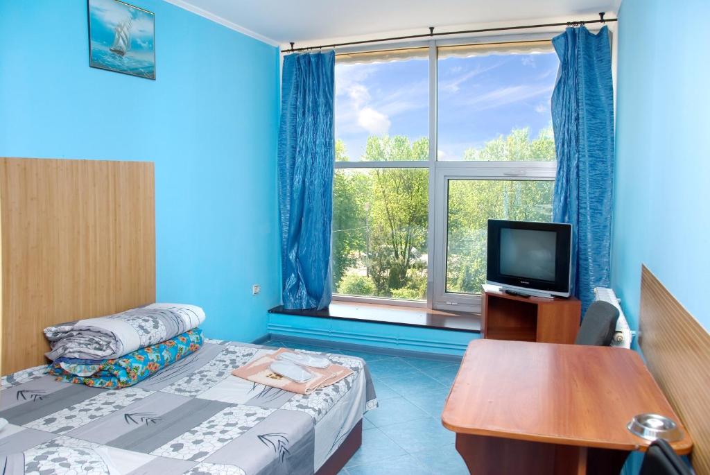 een kamer met een bed, een tv en een raam bij Galitsiya Hotel in Lviv