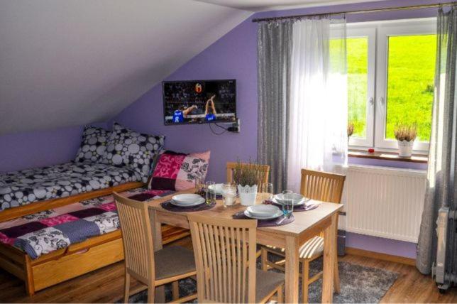 een woonkamer met een tafel en een bank bij Nocleg w Małastowie in Małastów