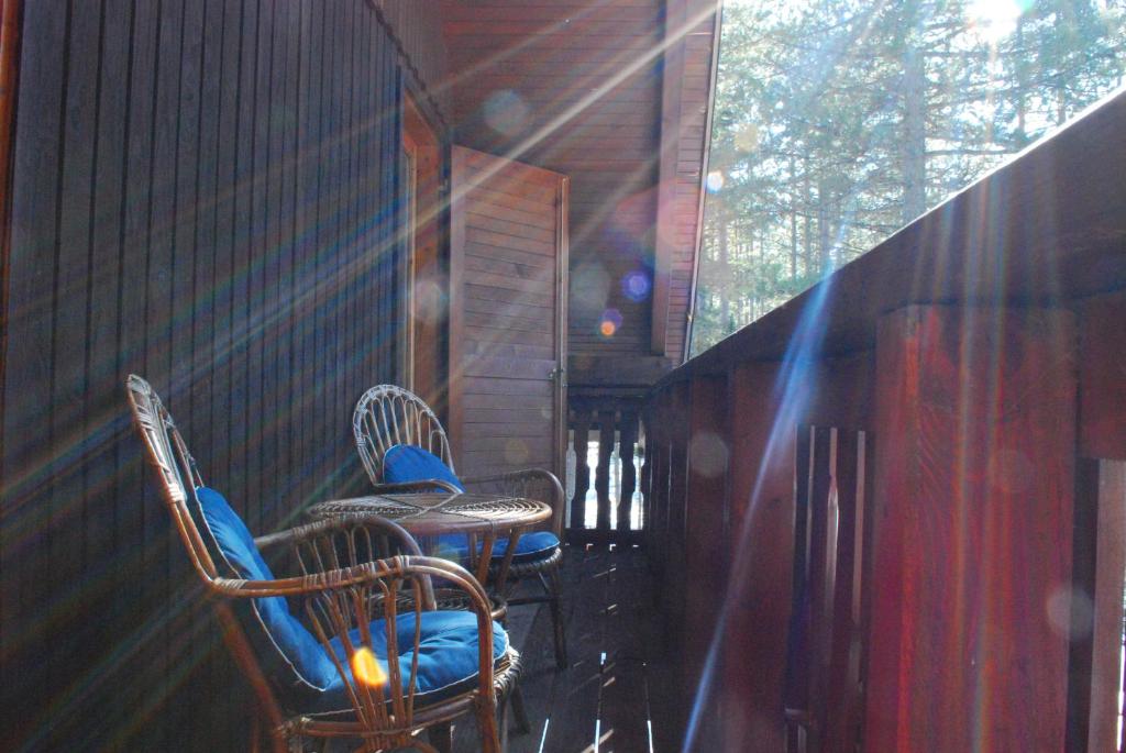 2 Stühle und ein Tisch auf einer Veranda in der Unterkunft Tarski dom in Zaovine