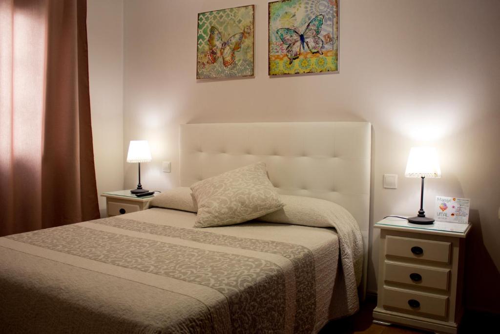 a bedroom with a bed and two night stands with lamps at Felisa Center in Arrecife