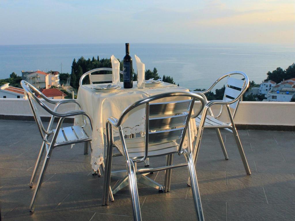 a table with two chairs and a bottle of wine at Days Inn Apartments in Ulcinj
