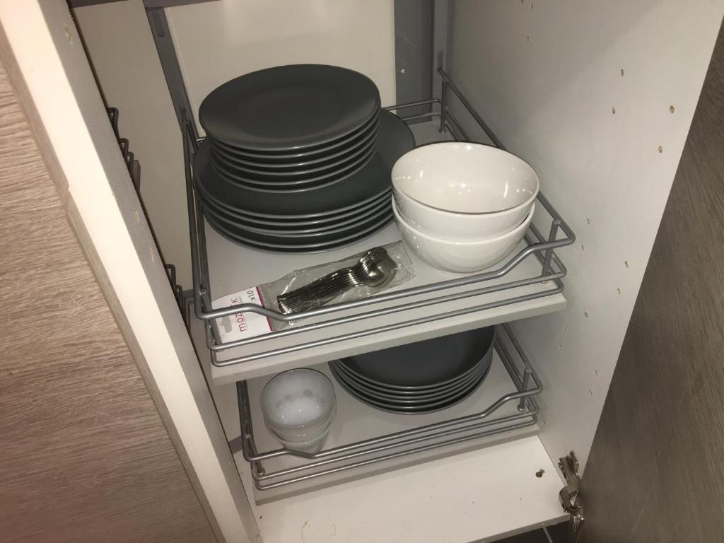a stack of plates and bowls on a shelf in a refrigerator at Catalans in Marseille