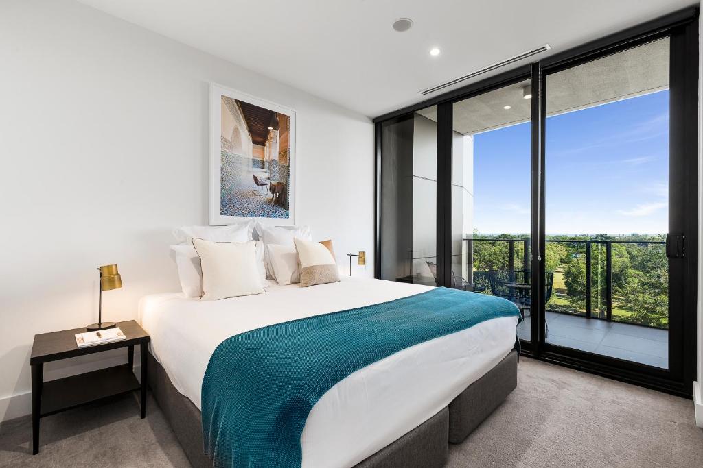 - une chambre avec un grand lit et une grande fenêtre dans l'établissement Tyrian Albert Park Lake, à Melbourne