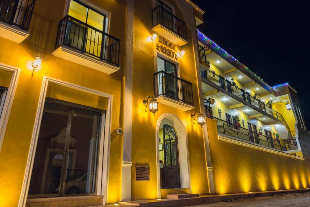 een geel gebouw met 2 balkons en een deur bij Hotel Rosalia in Valladolid