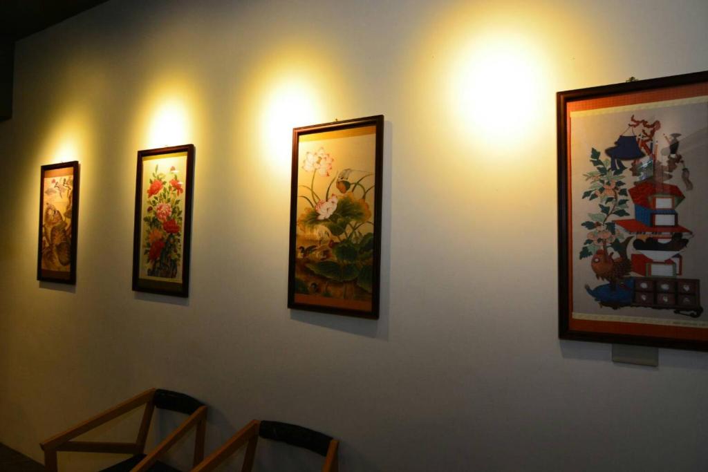a group of paintings on a wall with lights at 窗外的海 - 海洋公園旁 in Yanliau