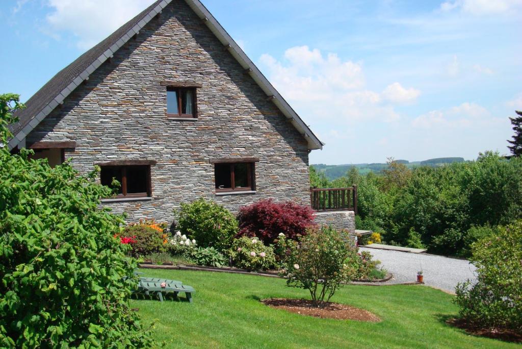 une maison en pierre avec un jardin en face dans l'établissement Gîte La Gernelle, à Bouillon