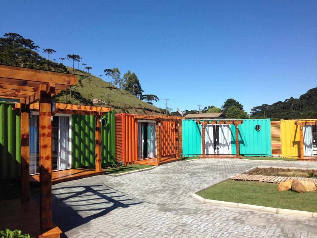 a row of colorful houses with a hill in the background at Villa dos Ventos Hospedagem Container in Bom Jardim da Serra