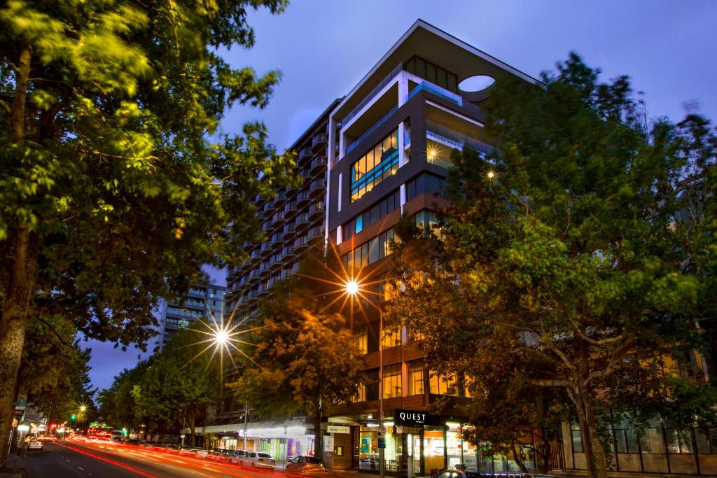 un edificio alto en una calle de la ciudad por la noche en Quest on Hobson Serviced Apartments, en Auckland
