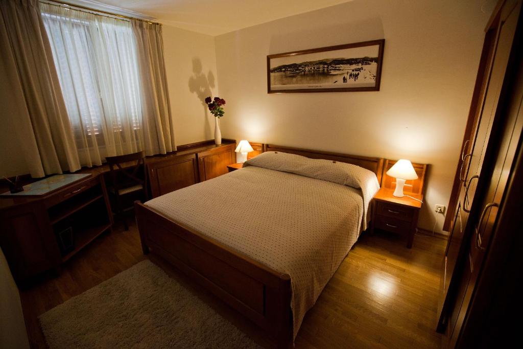 a bedroom with a bed and two lamps on two tables at Apartments Villa Castello in Crikvenica
