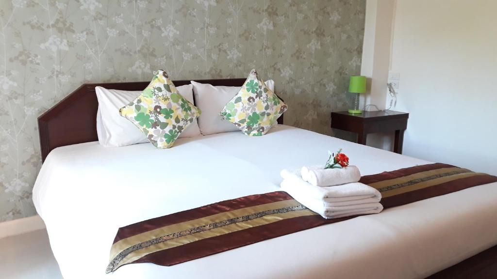 a bedroom with a white bed with towels on it at Chumphon Travelodge in Chumphon