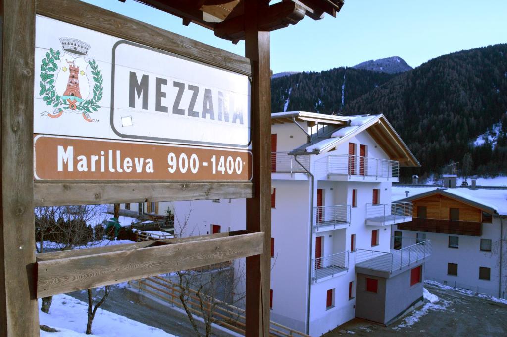 a sign in front of a building with a mountain at Appartamenti ai Stabli 2 in Mezzana