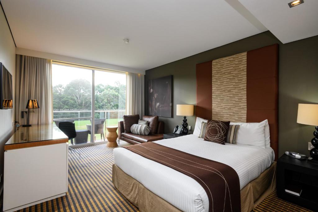 Habitación de hotel con cama grande y sofá en MGSM Executive Hotel & Conference Centre en Sídney