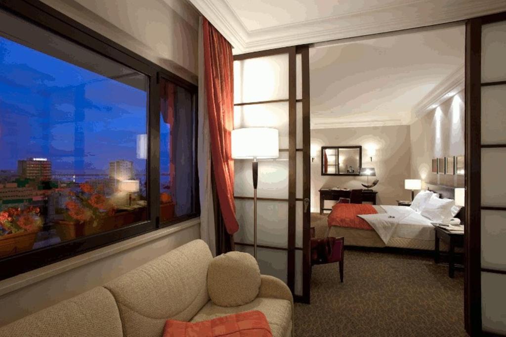ein Hotelzimmer mit einem Bett und einem großen Fenster in der Unterkunft Hotel Regina Margherita in Cagliari