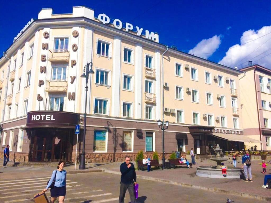 un hôtel avec des personnes qui marchent devant lui dans l'établissement Forum, à Tomsk