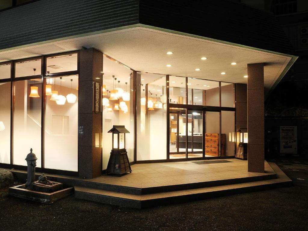 Shiobara Onsen Tokiwa Hotel في ناسوشيوبارا: واجهة متجر مع الكثير من النوافذ في الليل