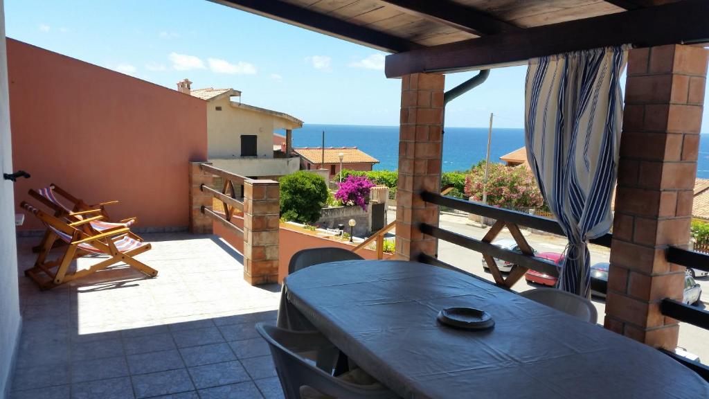 a balcony with a table and a view of the ocean at Blue view Alabe in Magomadas