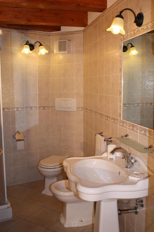 a bathroom with a sink and a toilet and a mirror at L'Antico Borgo B&B in Levanto