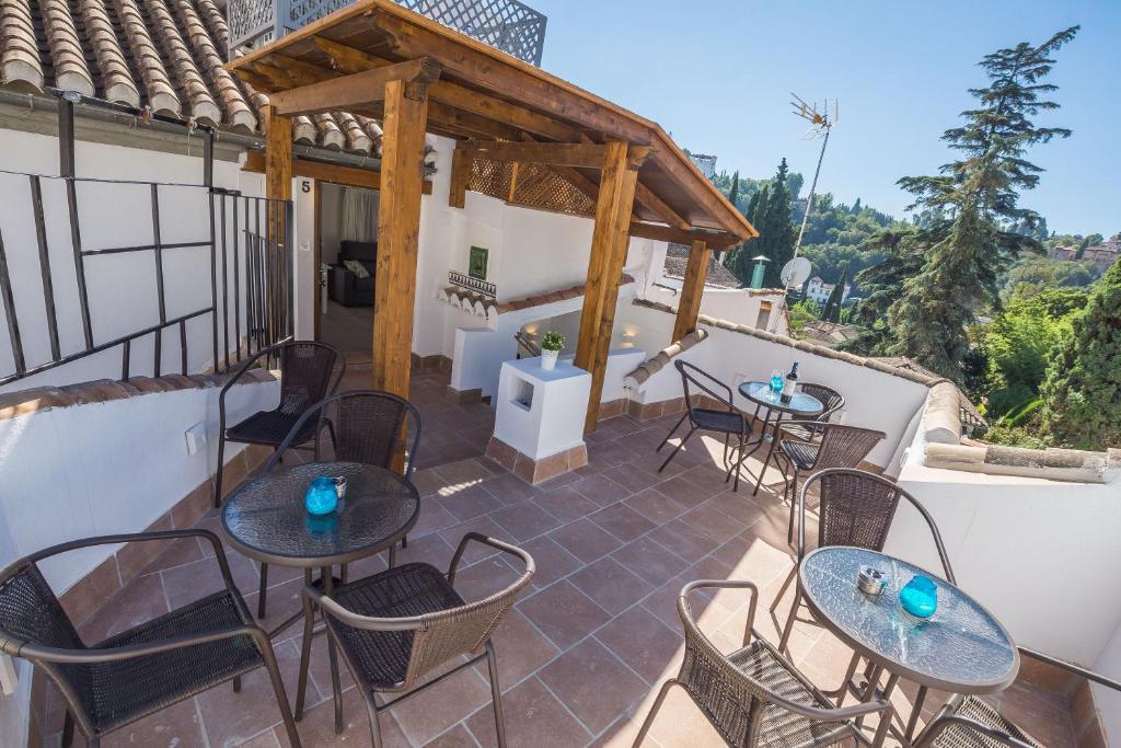 un patio con mesas y sillas en el balcón en Chapizhome en Granada