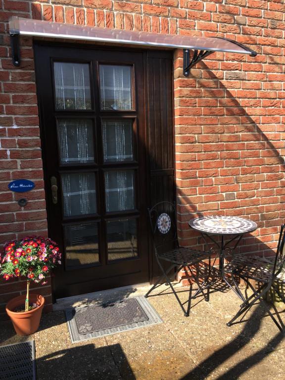 a patio with a black door and a table and chairs at Haus Osterwiese in Lüneburg