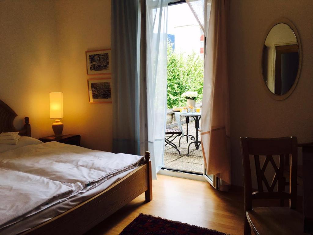 - une chambre avec un lit et une porte donnant sur une terrasse dans l'établissement Bottega del Vino Guesthouse, à Locarno