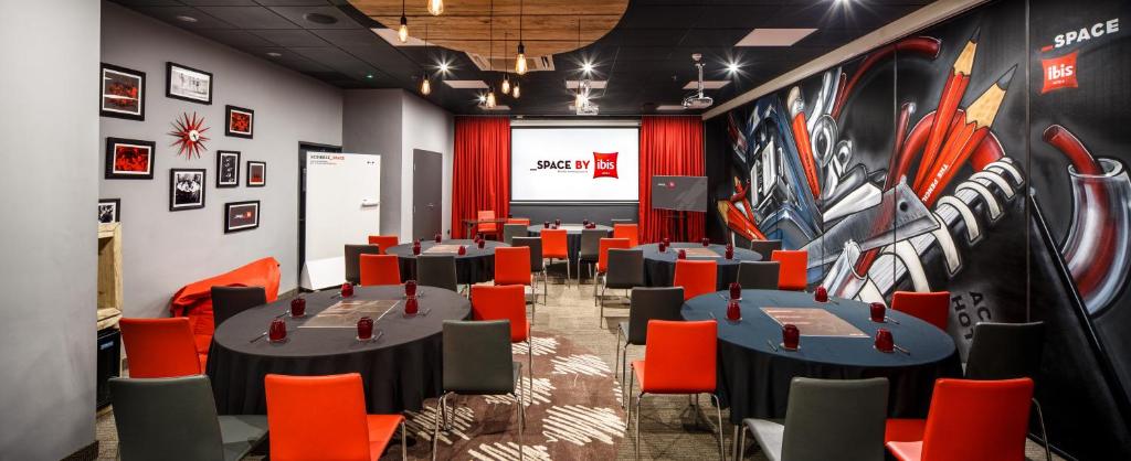 a conference room with tables and chairs and a screen at ibis Birmingham Centre New Street Station Hotel in Birmingham