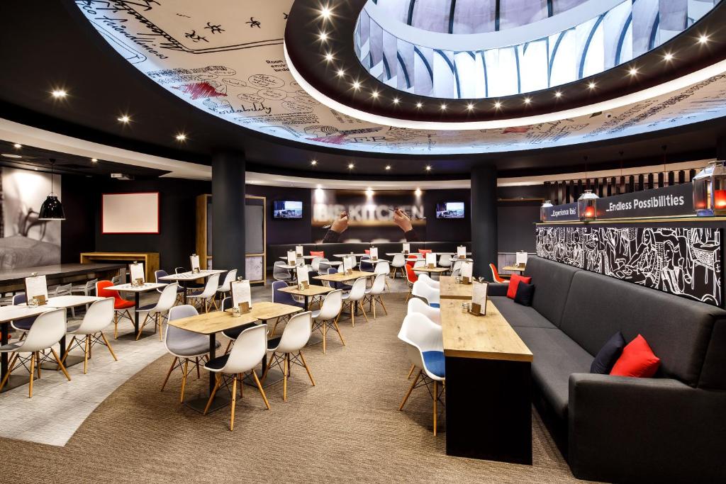 a restaurant with tables and chairs and a large ceiling at ibis Birmingham Centre New Street Station Hotel in Birmingham