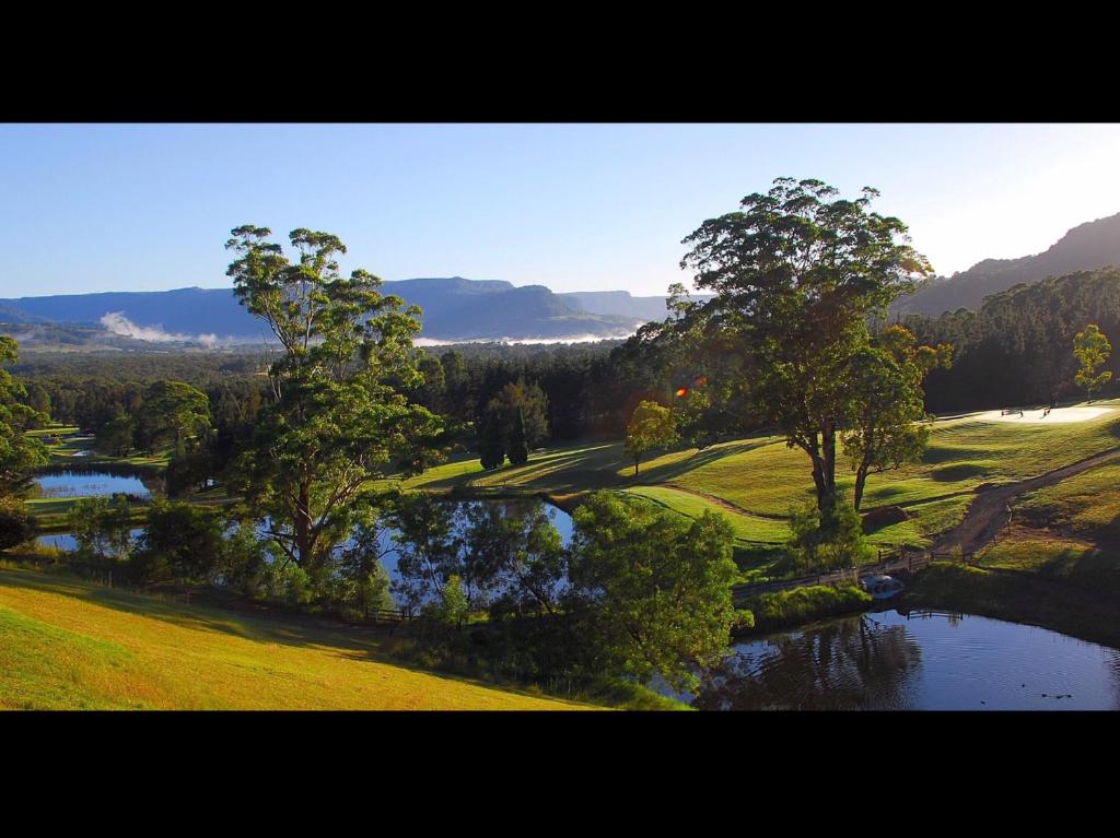 Blick auf einen Golfplatz mit Fluss und Bäumen in der Unterkunft SkyView Villa in Kangaroo Valley