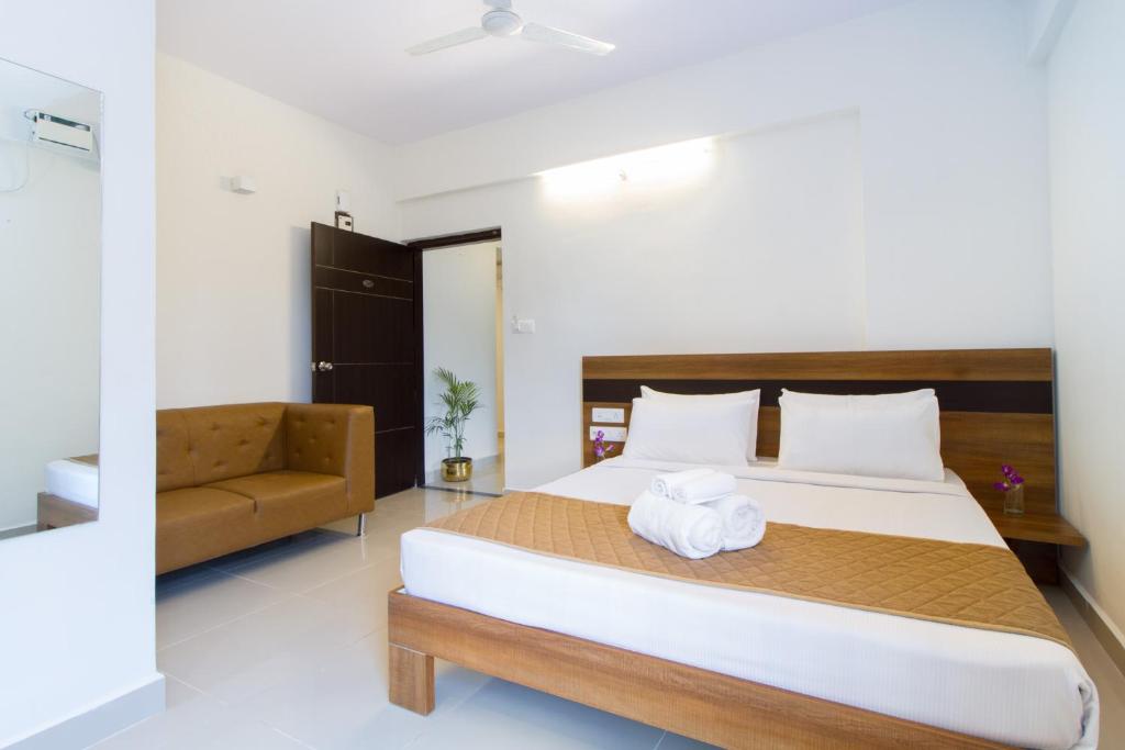 A bed or beds in a room at Sanctum Suites Whitefield Bangalore