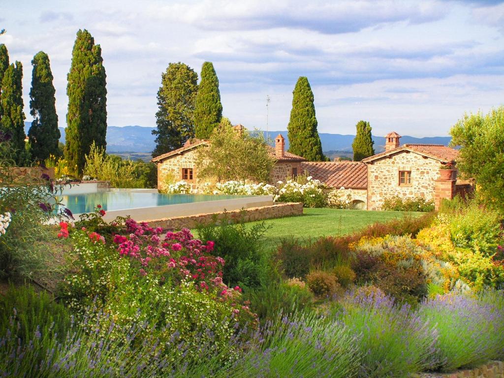 トッリータ・ディ・シエーナにあるVilla San Sanino - Relais in Tuscanyの家とスイミングプール付きの庭園